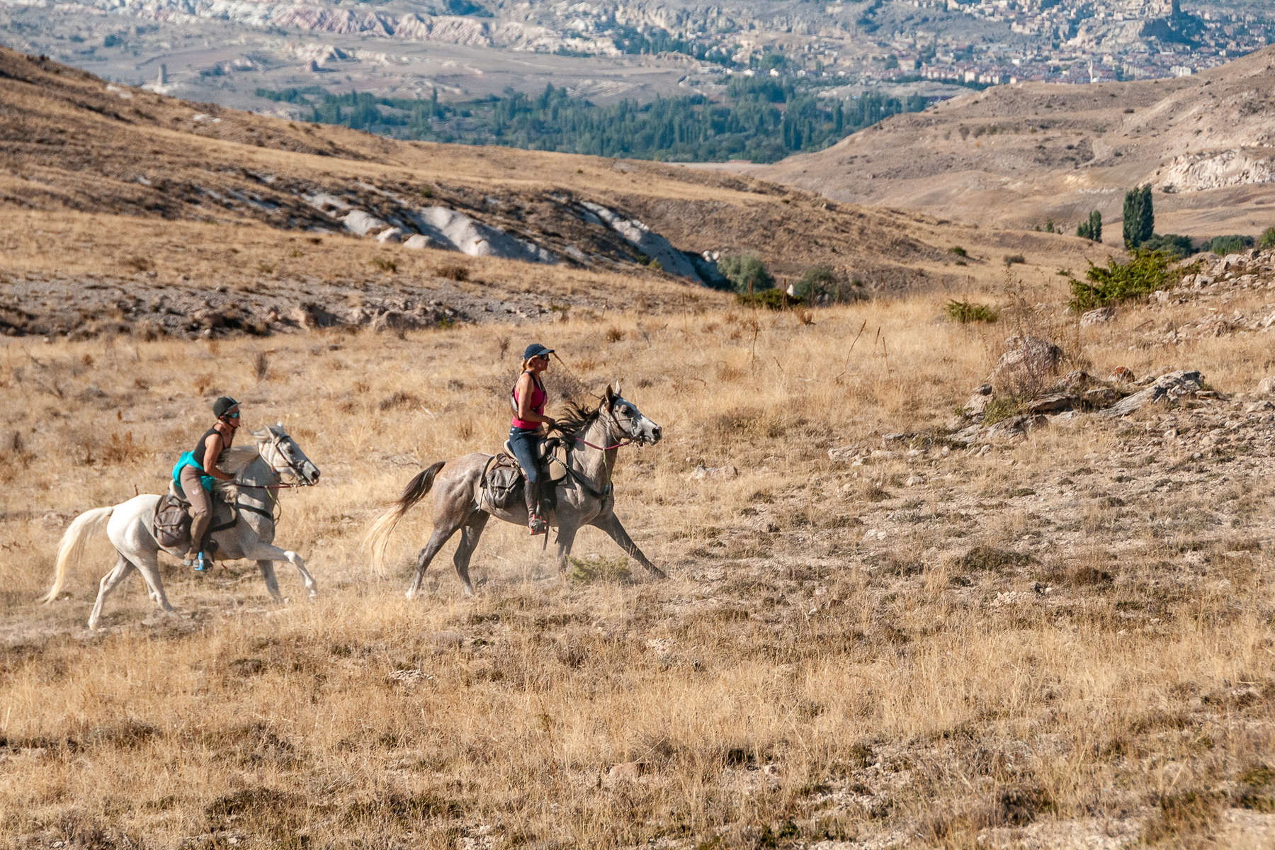 Two riders cantering and enjoying an active trail riding holiday