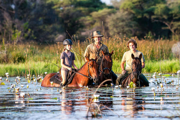 Family of riders in the floodplains of the Okavango delta