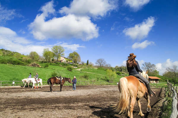 Horseback riders in a riding arena in Tuscany