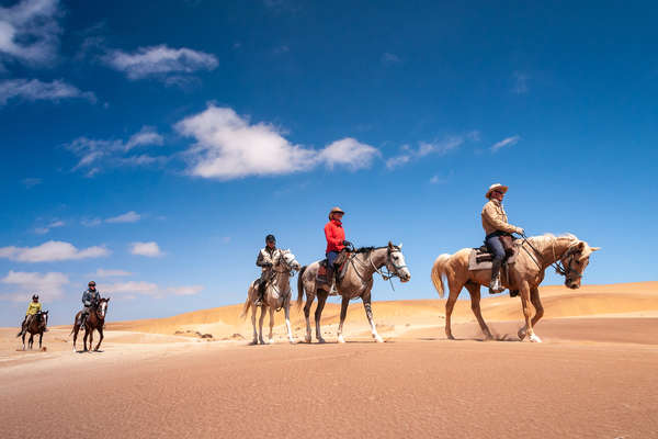 Horseback riders in the desert of Namibia