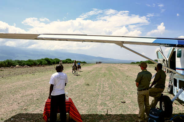 Riders cantering on an airplane track in Tanzania