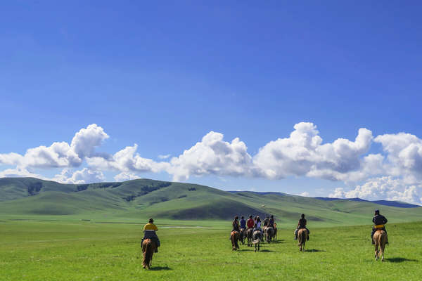 Riders riding across the steppe in the Khentii region of Mongolia