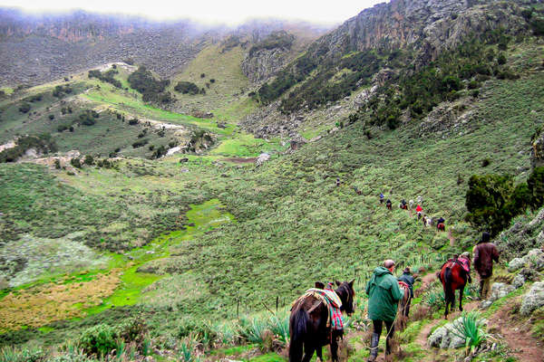 Riders riding down  a small canyon during a horseback holiday in Ethiopia