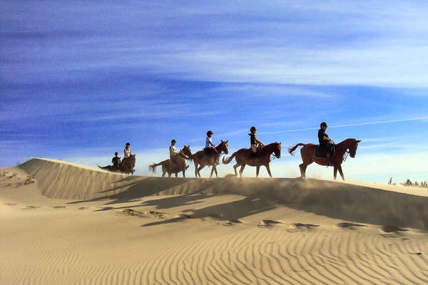 Trail riders in the sand dunes of Sardinia on horseback