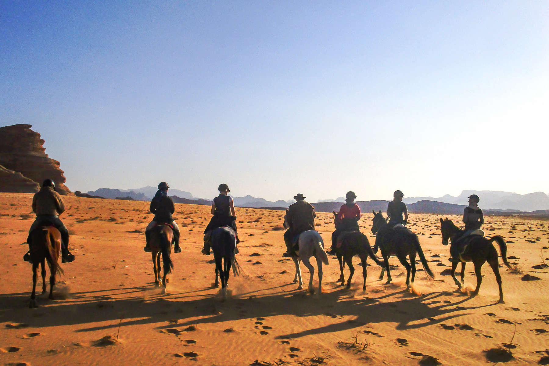 Group of horse riders riding along the desert in Jordan