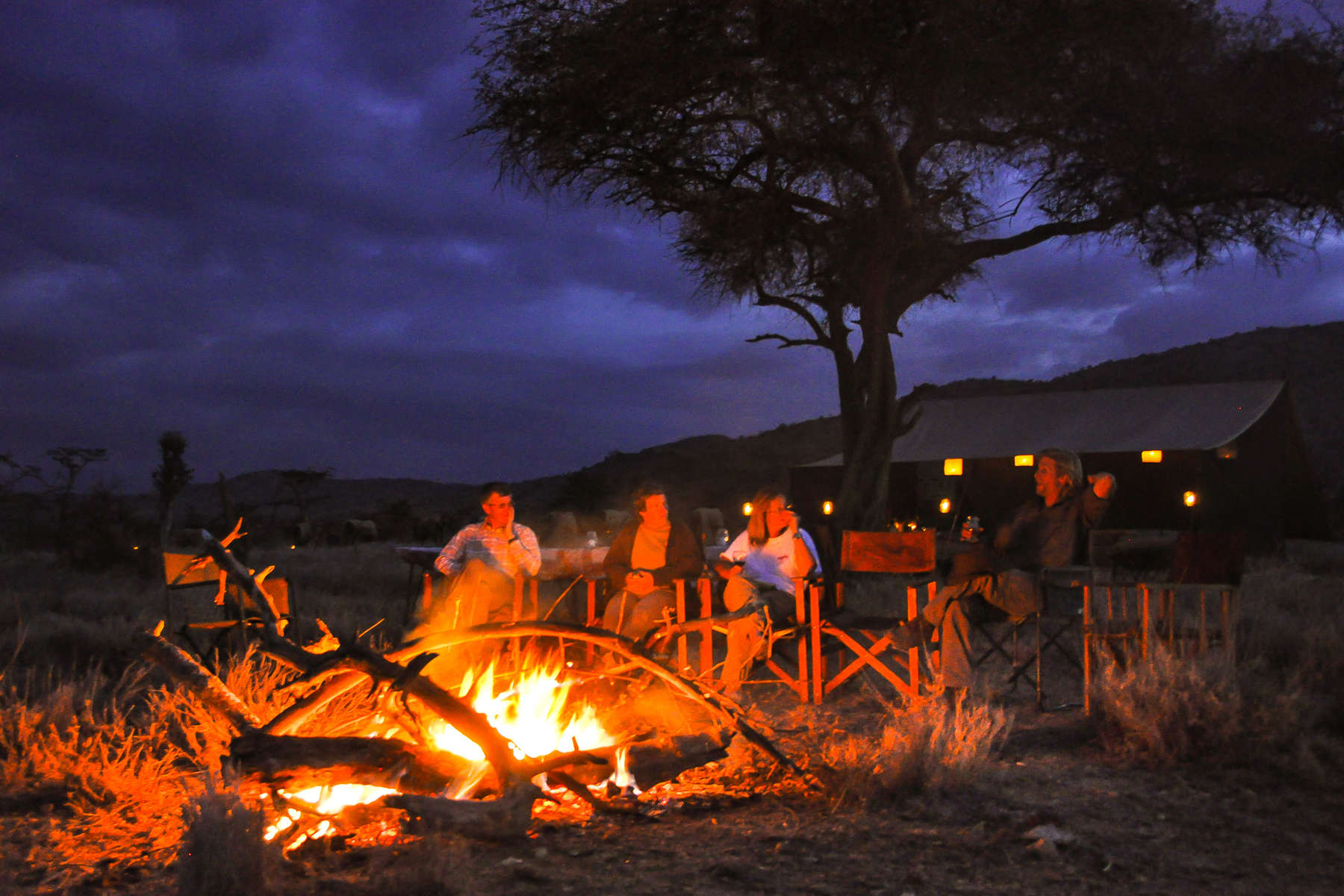 Group of riders around a bonfire at Borana Lodge, Kenya