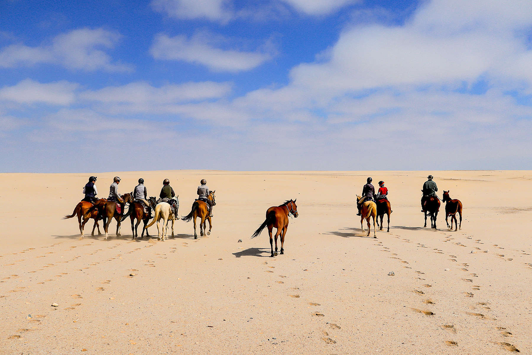 Multiple riders crossing a desert in Namibia