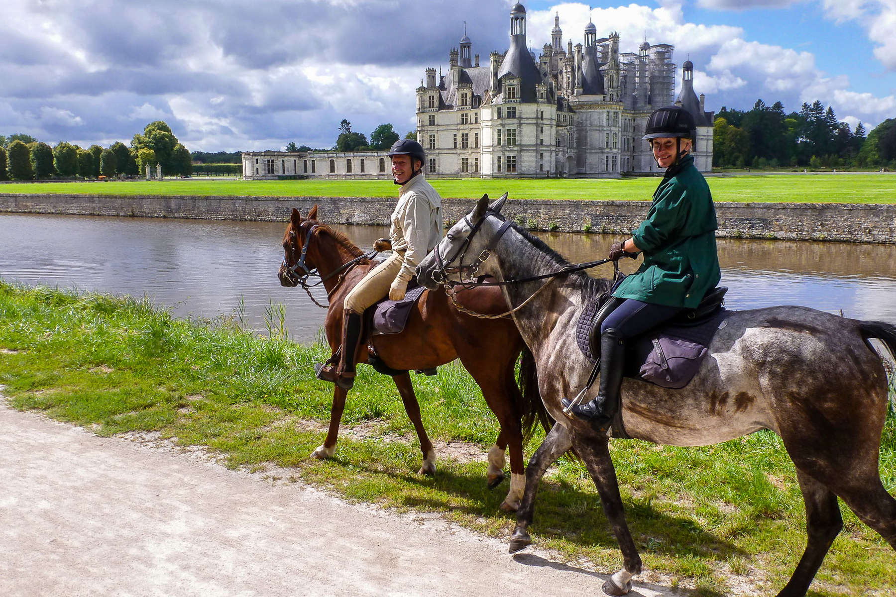 Two riders riding in front of Chambord in the Loire Valley