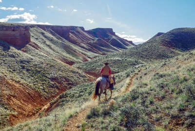 Horseback rider on a trail ride in Wyoming on a ranch holiday