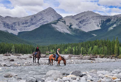 Horseback riders fording a river on horseback