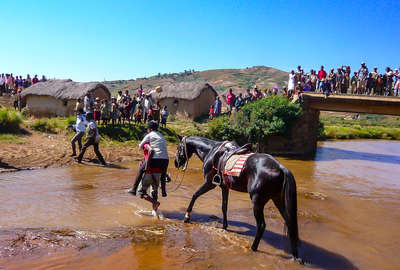 Rider guiding the horse through the water in Madagascar