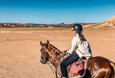 Rider riding through canyons in the Sahara in Morocco