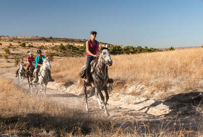 Riders cantering along a path in Cappadocia on an active trail ride
