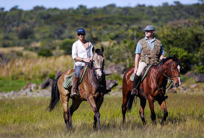 Riders walking along a field in Kenya