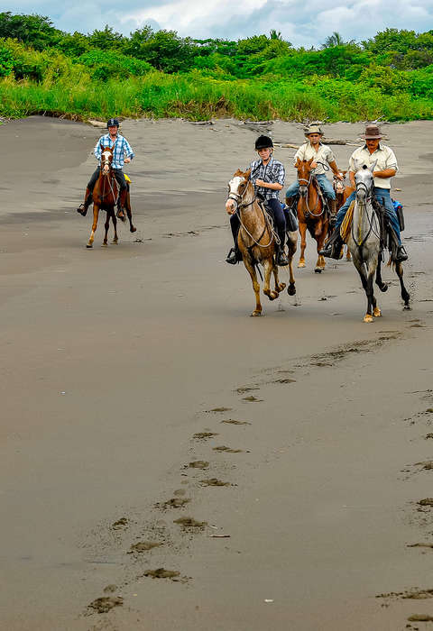 Group of riders cantering in a beach in Costa Rica