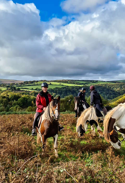 The Porlock ride, England Group of riders enjoying a trail riding holiday in Exmoor, riding over hills