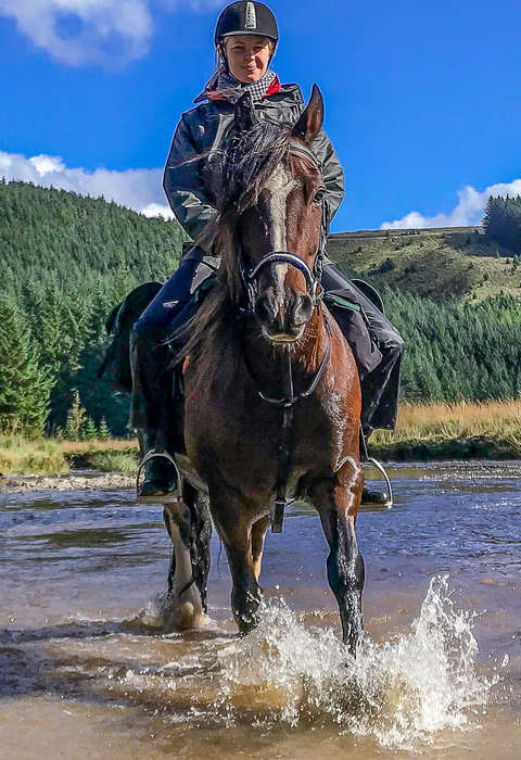 Enjoy a fun riding holiday in Wales Horse and rider riding in water in Wales
