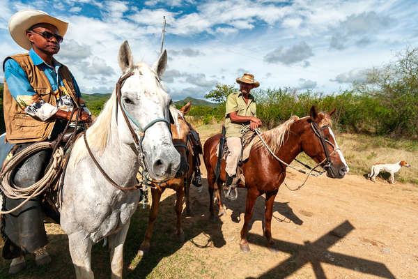 Couple of riders resting in a field in Cuba