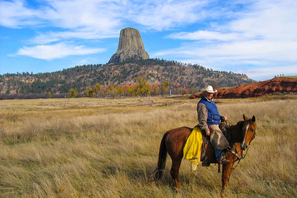 Cowboy posing in front of the Devil's Tower in Wyoming