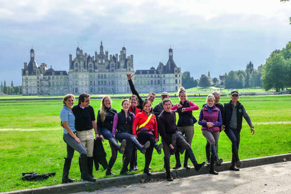 Group of riders, on foot, in front of Chambord castle in France