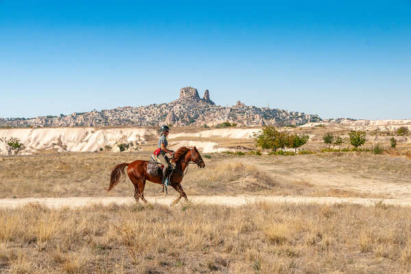 Horseback rider cantering in Cappadocia, on a trail ride