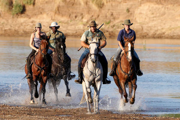 Horseback riders in a river in Limpopo, Botswana