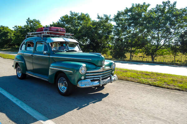 Old car moving through the local streets in Cuba