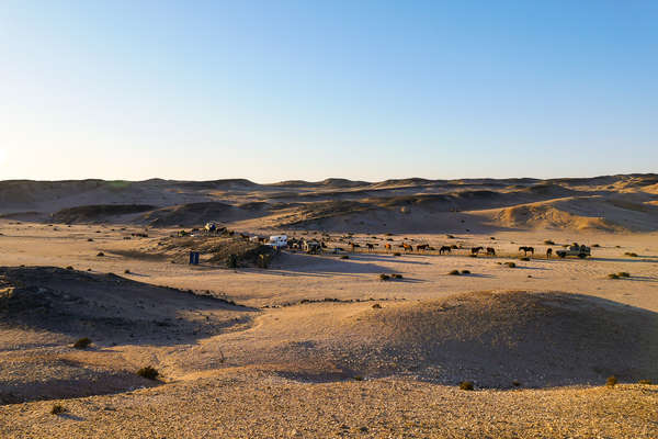 People setting up camp in a desert in Namibia