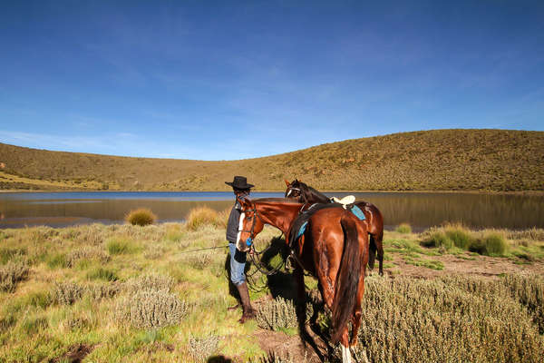 Rider standing by a lake in Kenya, Borana Conservancy