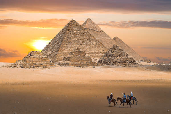 Riders approaching the pyramids in Egypt