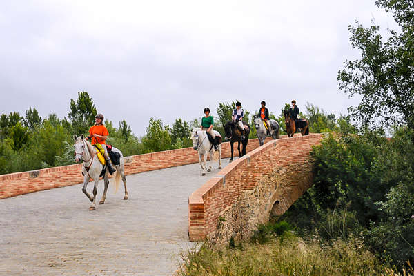 Riders coming over a bridge in Spain