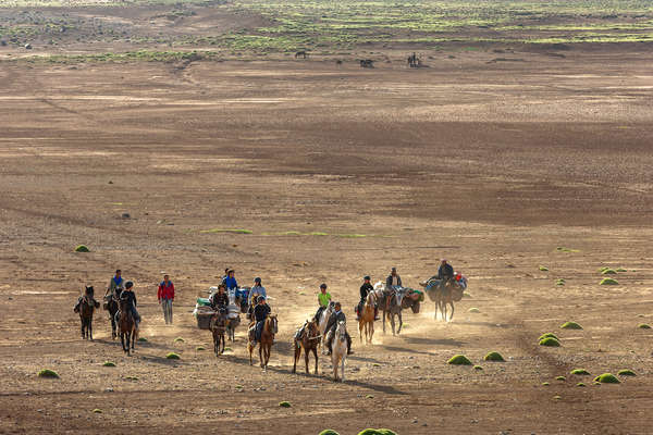 Riders crossing a valley in the Atlas mountains on horseback