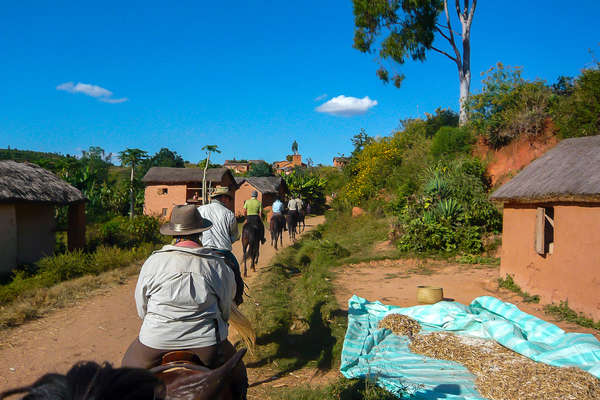Riders crossing a village in Madagascar