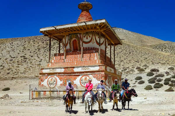 Riders in front of a temple in the Mustang area of Nepal