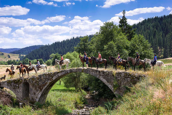 Riders posing for a photo on a bridge