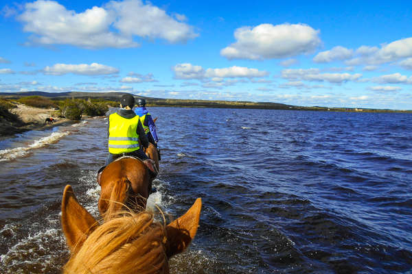 Riders riding in a small lake in Finland