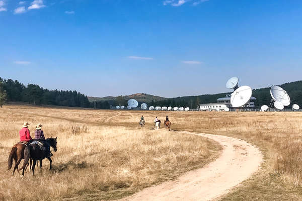 Riders riding near satellite dishes in Bulgaria