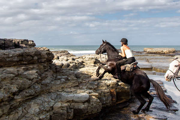 Trail rider climbing rocks on a riding holiday in South Africa