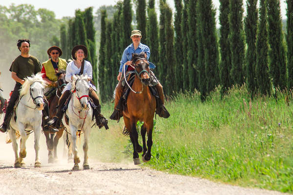 Trail riders cantering down a path in Tuscany