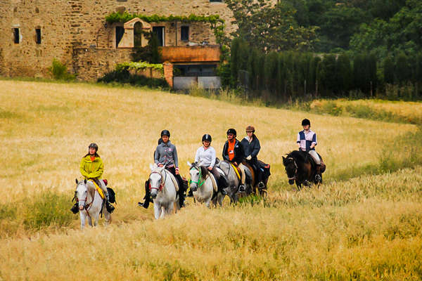 Trail riding holiday in Spain, riders crossing a field
