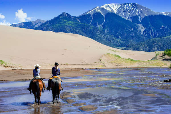 Two cowgirls riding in beautiful scenery in Colorado
