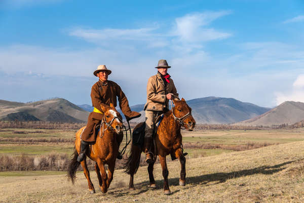Two riders on horseback in the Khentii mountains of Mongolia