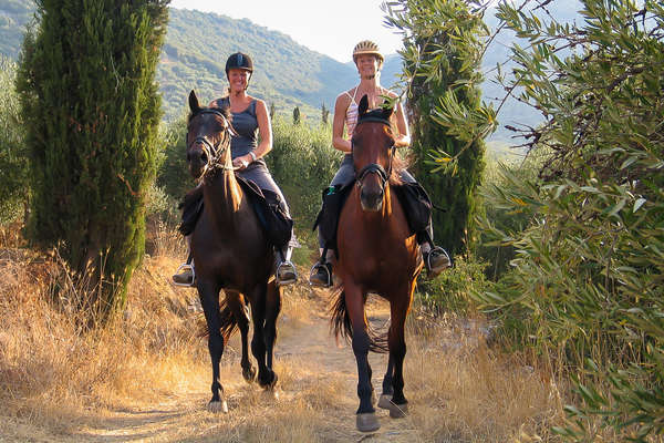 Two smiling riders on horseback in Crete