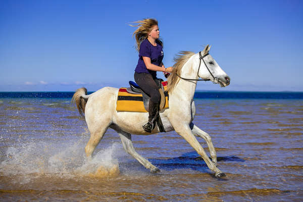 Woman riding along a beach in Mozambique
